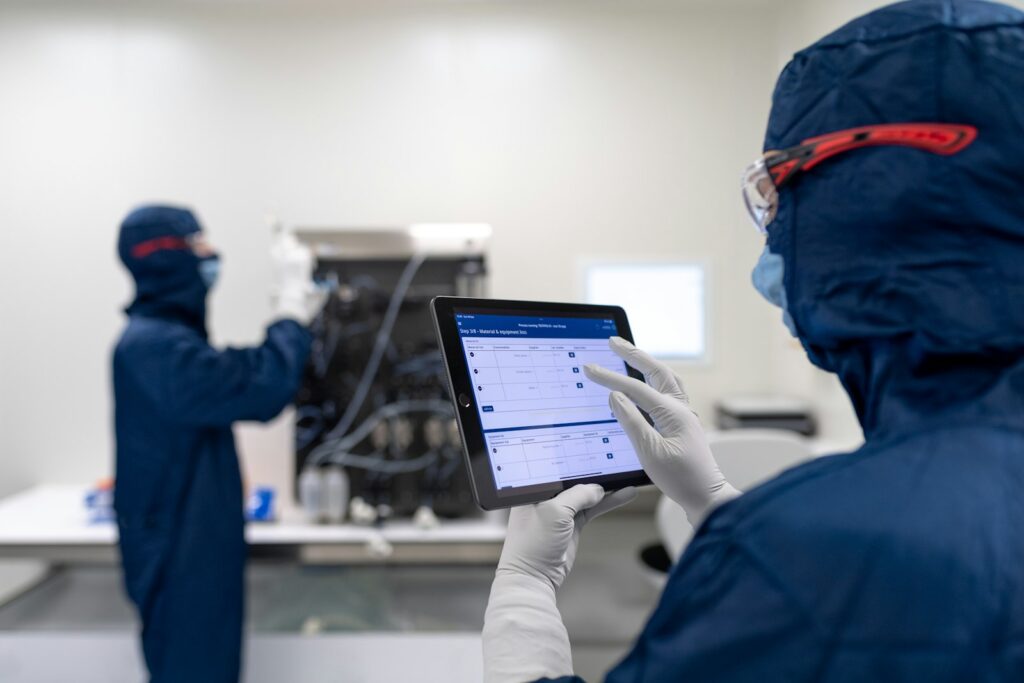 Engineers reviewing production data on a tablet